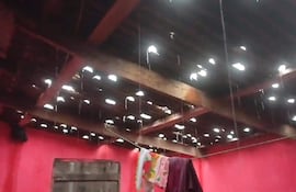 Techo dañado en vivienda, goteras visibles, paredes rojas y trapos colgados, indicando daño por granizada.