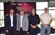 Cuatro hombres en trajes posan frente a un cartel de 'LADIES NIGHT', en un entorno luminoso con logotipos de sponsors.