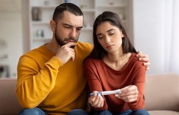 Hombre y mujer decepcionados por un resultado negativo de embarazo.