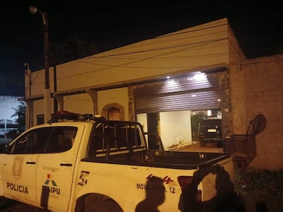 Vehículo policial con insignia 'POLICIA' y logo de Itaipú, en una noche urbana con edificación iluminada de fondo.