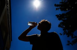 Hombre toma agua un día de calor.