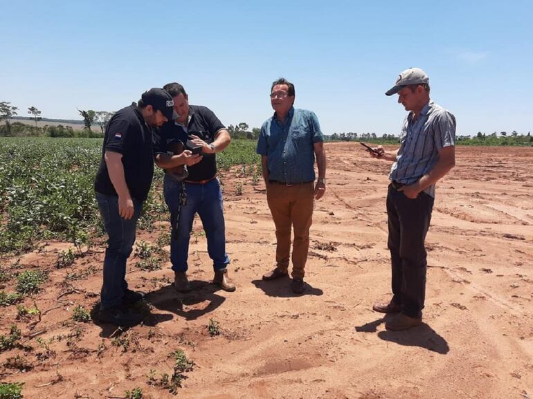 El fiscal José Godoy Blanco (muestra una imagen desde su celular) el día que hizo el allanamiento. El predio es de  Teodoro Valinotti (centro). Están investigados en el caso  Jacob Enns Fehr y Johan Eep Enns.