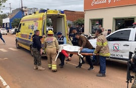 Bomberos y rescatistas en la calle, trasladando a un hombre cubierto con una manta en camilla.