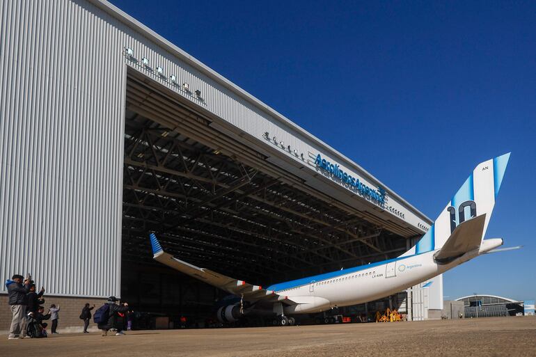  Fotografía que muestra avión plateado de Aerolíneas Argentinas ingresando a un hangar este jueves, en el Aeropuerto Internacional de Ezeiza en José María Ezeiza (Argentina). La línea aérea estatal Aerolíneas Argentinas presentó el avión que llevará a la selección argentina de fútbol al Mundial 2026, con un diseño que incorpora la camiseta número 10 del capitán y figura del equipo, Lionel Messi. EFE/ Juan Ignacio Roncoroni
