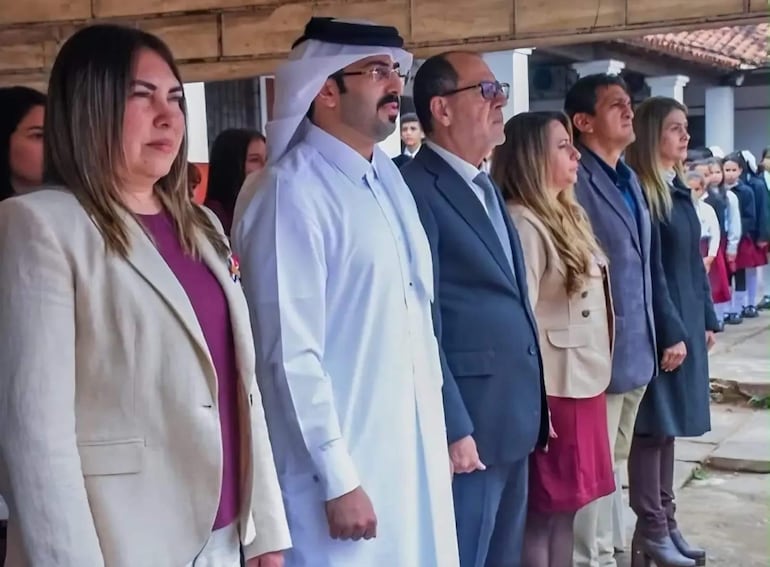 Mohammed Meshan Al-Shamari, vestido con túnica blanca y ghutrah, junto a otras personas en un evento formal, todos con semblantes serios.