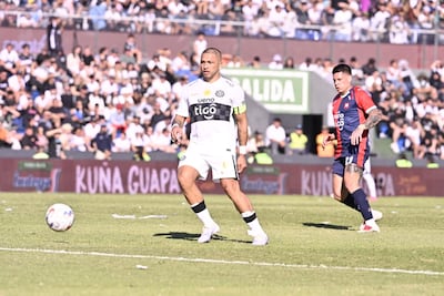 El capitán de Olimpia, Richard Ortiz extiende el pase ante la presencia del delantero de Cerro Porteño, Juan Manuel Iturbe.