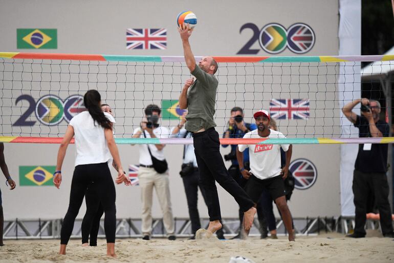 El príncipe William de Gran Bretaña juega al voleibol durante un encuentro con socorristas en la playa de Copacabana, en Río de Janeiro, Brasil. (Daniel RAMALHO / AFP)