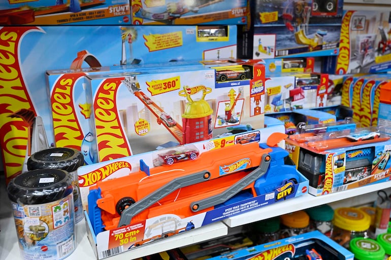 Estante lleno de juguetes Hot Wheels en colores azul, rojo y amarillo, sin figuras humanas visibles.