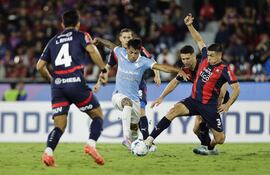 Matías Pérez (d), futbolista de Cerro Porteño, disputa el balón con Santiago González (c), jugador de Sporting Cristal, en un partido de la tercera fecha del Grupo G de la Copa Libertadores 2025 en el estadio La Nueva Olla, en Asunción, Paraguay.