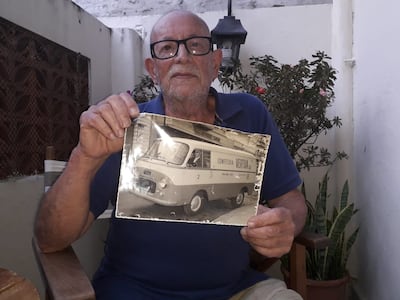 Francisco Vertua, hijo, sosteniendo una foto del vehículo de reparto de la Confitería Vertua.