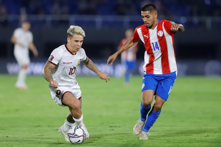 Héctor David Martínez (d), jugador de la selección paraguaya, disputa el balón durante un partido contra Venezuela por las Eliminatorias Sudamericanas al Mundial Qatar 2022, en el estadio Defensores del Chaco, en Asunción, Paraguay.
