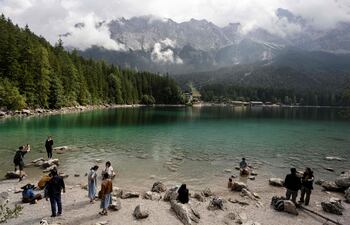 Turistas disfrutan de la vista sobre el lago Eibsee, en Grainau, cerca de Garmisch-Partenkirchen, en el sur de Alemania, el 22 de agosto de 2025.