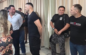 Ulises Quintana (de camisa celesa) conversa con Cucho Cabaña, en una de las jornadas de audiencia preliminar del caso Berilo. A la derecha el acusado Marcelo Cabaña habla con un guardiacárcel.