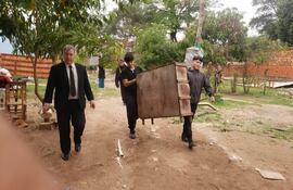 Ocupantes sacando sus pertenencias del terreno en conflicto.