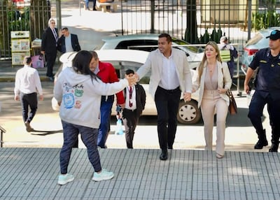 Miguel Prieto Vallejos, vestido con blazer claro, sonríe mientras estrecha la mano de una mujer con abrigo gris en un evento público.