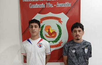Gabriel y Cristhian, ambos jóvenes de pie frente a un cartel policial, visten camisetas en blanco y negro con detalles gráficos.