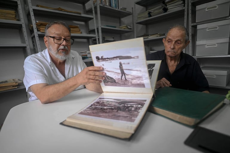 El coleccionista de Brigitte Bardot, José Wilson (izq.), y la residente de Búzios, Antonia Câmara (der.), muestran archivos de la visita de Bardot a la ciudad en la biblioteca municipal de Armação dos Búzios, en el estado de Río de Janeiro, Brasil, el 3 de enero de 2026.