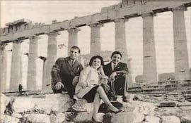 Johnny Torales en saco, Alma Vaesken con conjunto claro y Casto Martínez relajado, todos sonrientes en el Partenón.