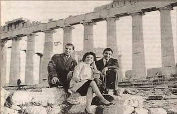 Johnny Torales en saco, Alma Vaesken con conjunto claro y Casto Martínez relajado, todos sonrientes en el Partenón.