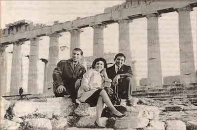 Johnny Torales en saco, Alma Vaesken con conjunto claro y Casto Martínez relajado, todos sonrientes en el Partenón.