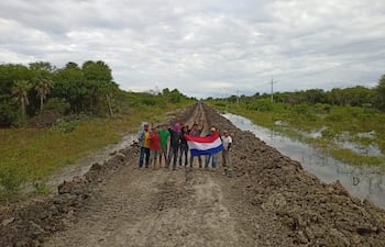 Voluntarios de la zona de Fuerte Olimpo, muestran la tricolor luego de completar la tarea de desagote del camino y permitir la rehabilitacion