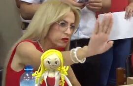 La concejala Carolina González en la Junta Municipal con una muñeca frente suyo.