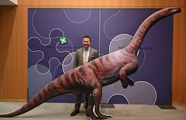 Franco Claretti, director del área de Lombardía del Parque Nacional del Stelvio, posa para una fotografía con un dinosaurio de cartón durante una conferencia de prensa para presentar el descubrimiento de miles de huellas de dinosaurios halladas en el Parque Nacional del Stelvio, en Italia, cerca de las zonas que albergarán los Juegos Olímpicos de Milán-Cortina 2026, en Milán, el 16 de diciembre de 2025.
