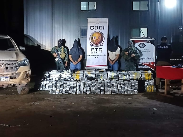 Los detenidos Ariel Arrúa Galeano y Edson Giménez Acosta, custodiados por agentes antidrogas.