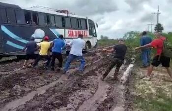 Basta un pequeño aguacero para que los caminos queden destrozados, las personas pasan penurias, foto de archivo del transporte público estirado por los pasajeros.