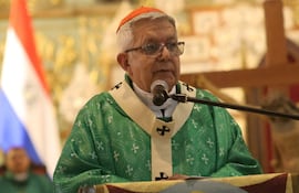 Adalberto Martínez, de cabello blanco y gafas, habla en vestimenta religiosa verde, junto a figuras similares, con banderas al fondo.