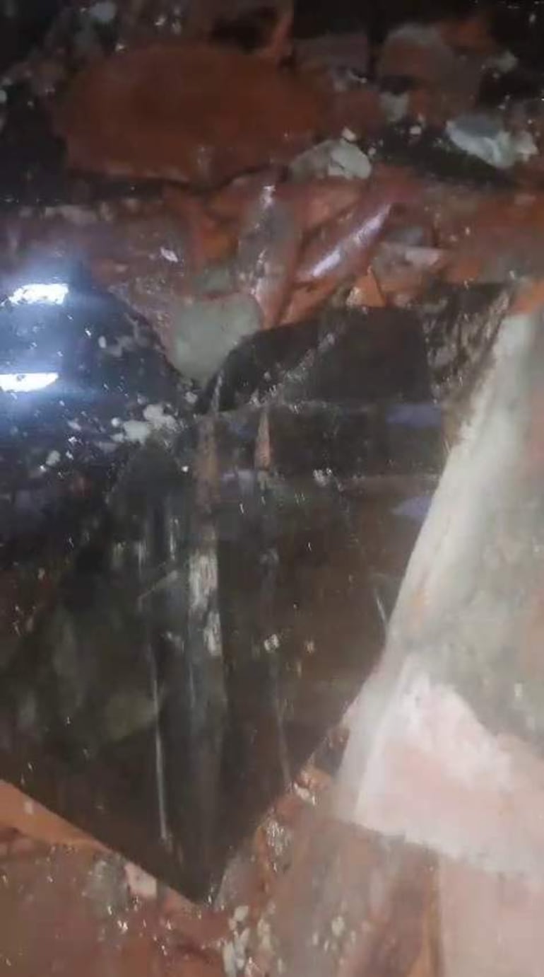 Escombros del panel de vidrio y restos del techo de la vivienda tras el desprendimiento de un vidrio de blindex en la Corte.