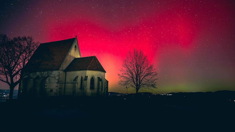 La aurora boreal, o luces del norte, se observa sobre la iglesia de Wenzel (Wenzelskirche) en Wartberg ob der Aist, Alta Austria, el 19 de enero de 2026.