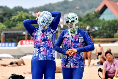 Dos mujeres en Qingdao, en la provincia de Shandong, China, se exponen al sol con "carakinis".