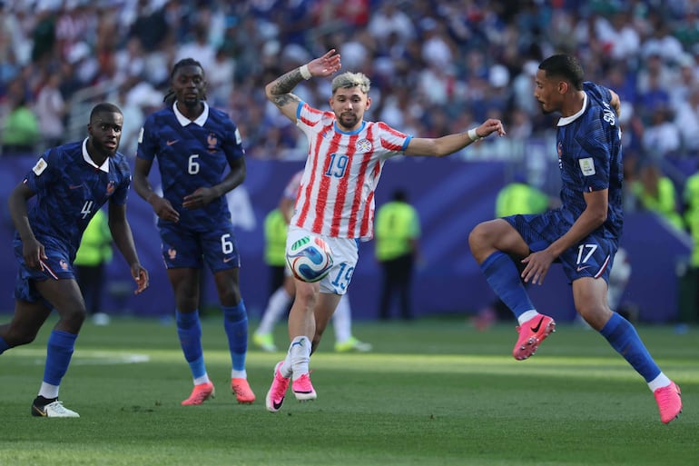 El centrocampista paraguayo Julio Enciso (C) y el defensa francés William Saliba (D) disputan el balón ante el defensa francés Dayot Upamecano durante el partido de octavos de final de la Copa del Mundo 2026 entre Paraguay y Francia, en el Philadelphia Stadium de Filadelfia.