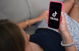 Una adolescente revisa TikTok en su teléfono celular.