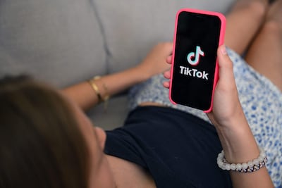 Una adolescente revisa TikTok en su teléfono celular.