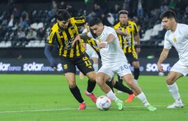 El extremo de Libertad, Hugo Fernández intenta avanzar ante la marca del delantero de Guaraní, Derlis Rodríguez.