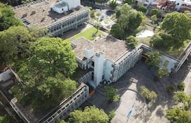 Vista aérea de un edificio moderno con áreas verdes, sin personas visibles en el entorno urbano.