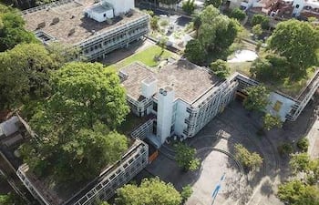 Vista aérea de un edificio moderno con áreas verdes, sin personas visibles en el entorno urbano.