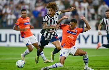 El experimentado atacante peruano Paolo Guerrero no puede superar la marca del zaguero central colombiano Juan Camilo Saiz. De fondo observa la acción Miguel Barreto.
