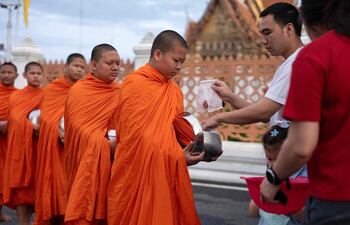 Monges budistas fuera de un templo en  Bangkok, Tailandia.
