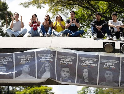 Estudiantes sostienen una pancarta con imágenes de presos políticos, en Venezuela.