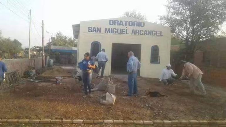 Grupo de seis personas trabajando en la construcción, dos hombres y una mujer mezclando cemento en un sitio al aire libre.