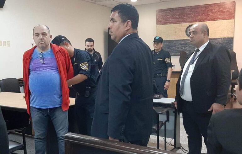 Antonio Carlos Bernardino (de remera azul) y Abdul Amir Melhem (de campera negra) son esposas por un efectivo policial tras conocer la sentencia. 