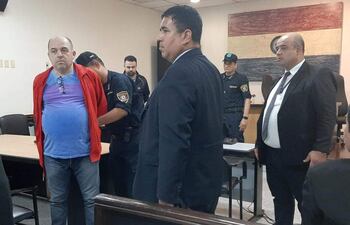 Antonio Carlos Bernardino (de remera azul) y Abdul Amir Melhem (de campera negra) son esposas por un efectivo policial tras conocer la sentencia.