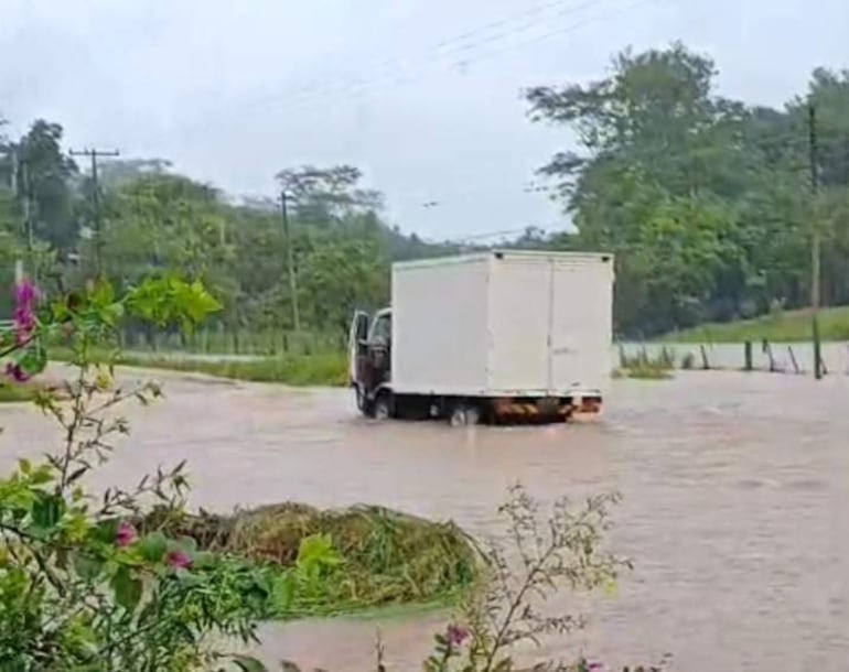 Un camión de carga queda estancado en medio del camino completamente inundado tras una torrencial lluvia