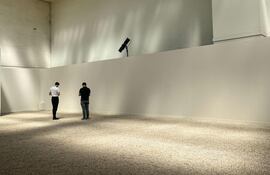 Dos visitantes alrededor de la pieza central de 'Cruz del sur' (1969), la instalación artística del brasileño Cildo Meireles. (Val Torres/EFE)
