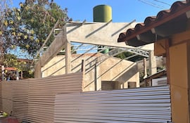 Ambiente de construcción con estructura de hormigón y tanque de agua en fondo, sin personas visibles.