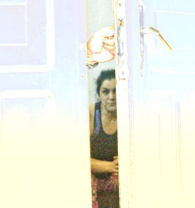 A través de la puerta entreabierta de una sala en la cárcel del Buen Pastor se puede ver a Carmen Villalba mientras espera la llegada del féretro de su hermano, Osvaldo Villalba.