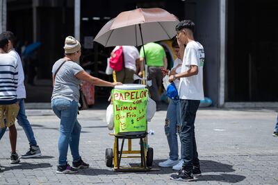Una mujer vende bebidas en una calle en Caracas (Venezuela). La Red Sindical Venezolana dijo este viernes que considera imposible celebrar unas Navidades “felices” debido a los bajos ingresos y la migración, por lo que prepara una protesta para exigir, entre otros asuntos, un incremento de la bonificación que reciben los trabajadores públicos a finales de año, conocida como aguinaldo.